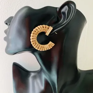 Bohemian C-shaped handmade rattan woven hoop earrings with gold metal studs on model