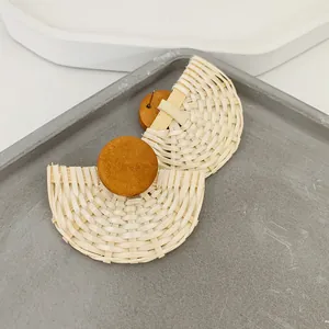 Detail der handgewebten fächerförmigen Ohrringe mit runden Holzsteckern auf einem Tablett