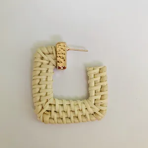 Detail of bohemian rattan earring featuring woven texture and gold hammered metal accent