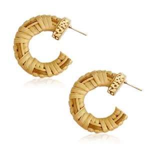 Handmade bohemian C-shaped rattan earrings with textured gold metal and natural straw weave
