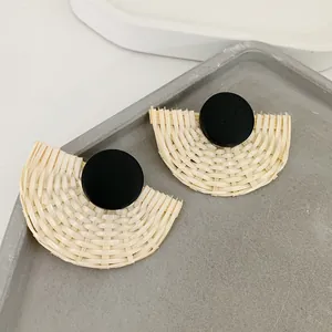 Detailansicht handgefertigter geflochtener Rattan-Ohrringe in Fächerform mit schwarzem Stecker