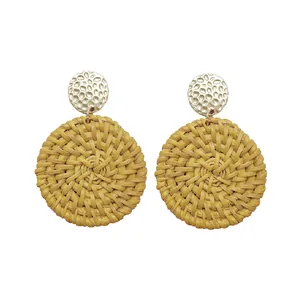 Macro shot of Bohemian rattan earrings featuring silver textured metal and woven fiber