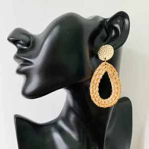 Bohemian gold hammered metal and natural rattan teardrop earrings on a black mannequin