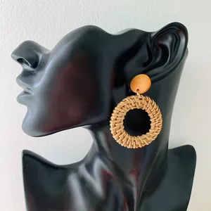 Handmade bohemian rattan woven hoop earrings on a display stand for women