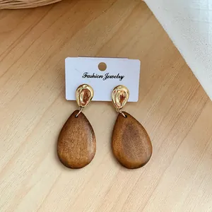Auffällige geometrische Holz-Ohrhänger in Tropfenform mit gehämmerten goldenen Metallsteckern