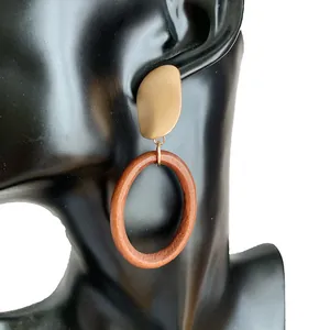 Detailansicht böhmischer geometrischer Ohrringe aus Holz und Goldmetall an einem Modell