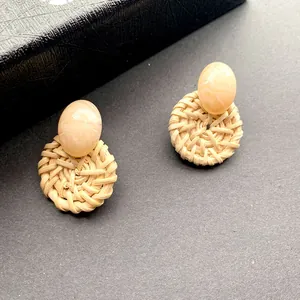 Detail van bohemien rotan oorbellen met marmerhars bovenkant en gevlochten textuur
