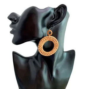 Detail showing handmade natural straw woven hoop earring on a mannequin model