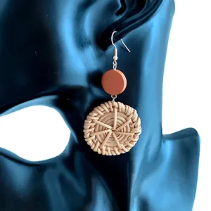 Handmade bohemian straw earrings with red disc and round woven pendant on black model