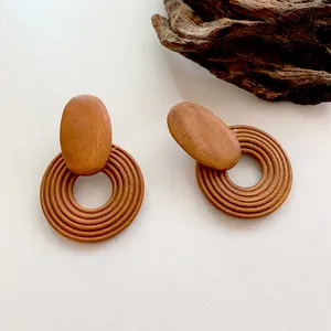 Detail of vintage geometric wood hoop earrings with concentric spiral texture and brown grain