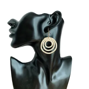 Ethnic straw woven drop earrings with triple nested circles on a black model silhouette