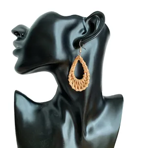 Detail of bohemian teardrop woven rattan earring on a black mannequin display