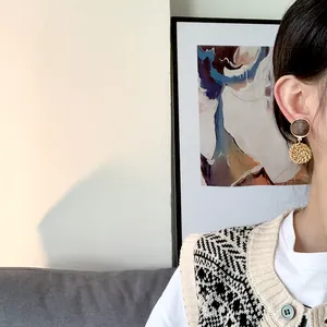 Bohemian rattan drop earrings featuring dark wood discs with gold metal frames