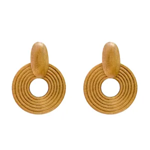 Macro detail of geometric wooden drop earrings with bohemian circular ribbed texture