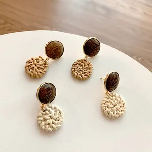 Handmade geometric rattan earrings with round wood studs and golden metal accents