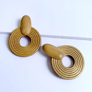 Detail view of large geometric wooden hoop earrings with concentric grooved texture