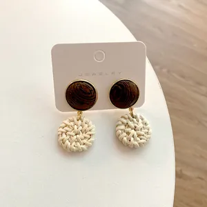 Handcrafted round rattan woven earrings with wood accents and gold metal trim