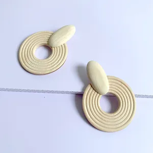 Macro detail of geometric wooden earrings featuring natural concentric ring textures