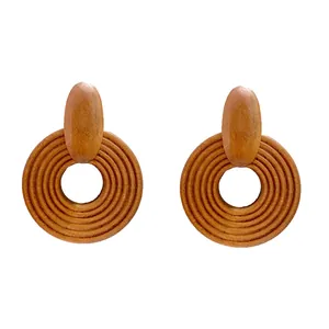 Detail of wooden geometric round earrings showing fine concentric spiral textures on surface