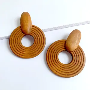 Macro view of geometric wooden hoop earrings with concentric ring texture in natural wood