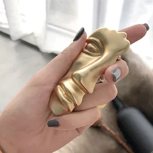 Artistic gold matte abstract face ring with sculpted features and brushed metal finish