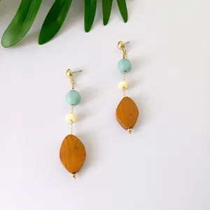 Detalle de pendientes largos con colgante de madera y cuentas de acrílico de colores