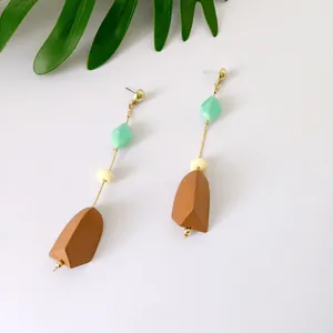 Detalle de pendientes geométricos de madera con cuentas de resina y acrílico de color