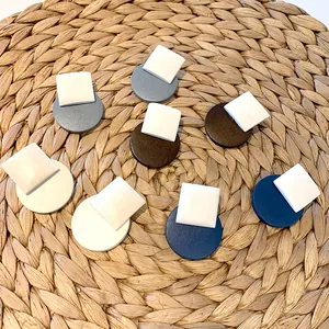 Detail of geometric wood resin earrings in assorted colors on a woven mat surface