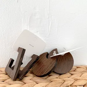 Detailed close-up of dark brown wooden earrings with geometric shapes on display card