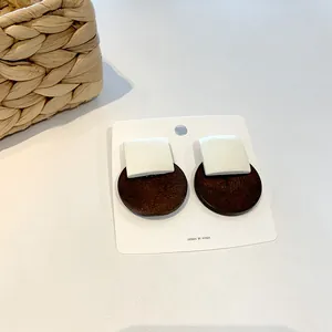 Detail of geometric wood and resin earrings with square and circular drop design