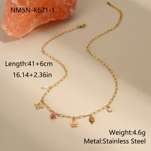 Detalle de collar de acero inoxidable dorado con colgantes de estrella, perla y gema