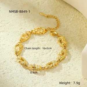 Dettaglio di bracciale a catena dorata con maglie martellate e chiusura a moschettone