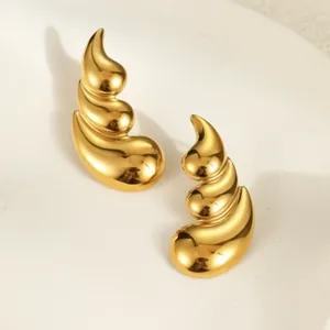 Primer plano de pendientes de titanio dorado en espiral de tres capas con brillo pulido