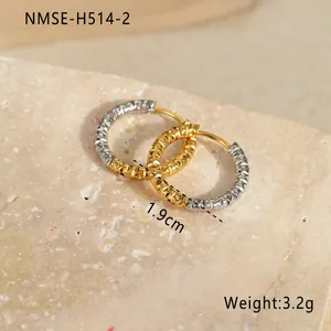 Detail der gold-silbernen Ohrringe mit 1,9 cm Größe und diamantgeschliffener Textur