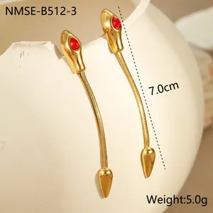 Détail de boucles d'oreilles serpent avec yeux en zircon rouge et fines chaînes dorées