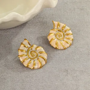 Detailed close-up of 18K gold plated conch spiral earrings with white shell inlay