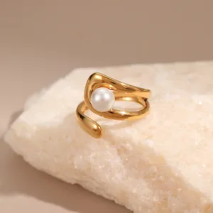 Detailansicht eines 18K vergoldeten Wickelrings mit einer zentralen weißen Perle