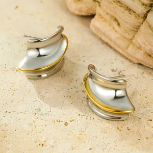 Two-tone wavy geometric stainless steel earrings on a natural stone background