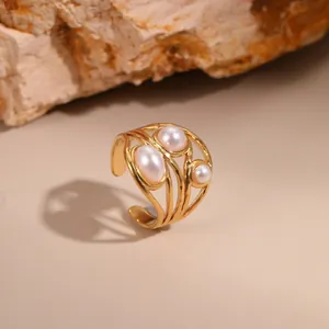Detail eines 18K vergoldeten Rings mit drei Perlen auf natürlichem Steinhintergrund