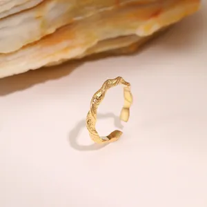 Macro shot of gold-plated ring with hammer texture on natural rock pedestal
