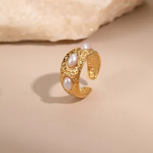 Detailansicht des gehämmerten 18K Goldrings mit drei weißen Perlen auf Natursteinbasis