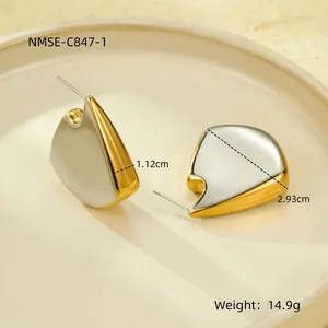 Macro shot of gold and silver abstract earrings on tray with 2.93cm height dimension