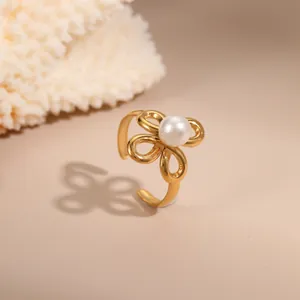 Detailaufnahme von 18K vergoldetem offenem Ring mit vierblättriger Blume und Perle