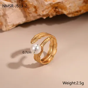 Detailansicht eines 18K Gold Federrings mit einer 0,7cm weißen Perle auf Steingrund