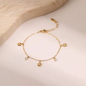 Detail of 18k gold plated titanium bracelet with star charms and sparkling zircons