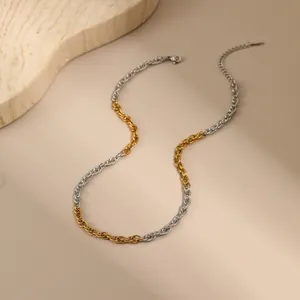 Detail of a two-tone twisted chain necklace in gold and silver with a lobster clasp closure
