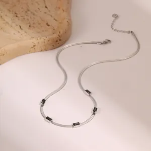 Vue détaillée du collier chaîne serpent argenté avec cinq zircons rectangulaires noirs