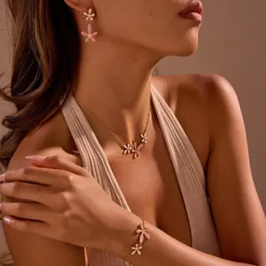 Detailopname van emaille bloemensieradenset met ketting, armband en oorbellen op model