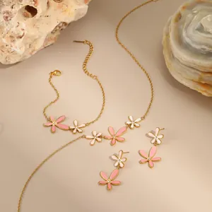 Gouden bloem sieradenset met roze emaille ketting, armband en oorbellen op stenen