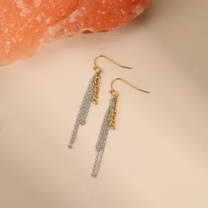 Modern two-tone gold and silver stainless steel tassel drop earrings on neutral stone